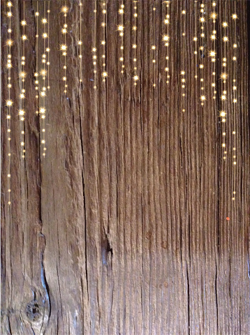 Vector illustration of a rustic wooden textured background with sparkling string lights.