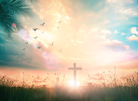 Resurrection of Jesus Christ concept: Silhouette cross on meadow autumn sunrise background