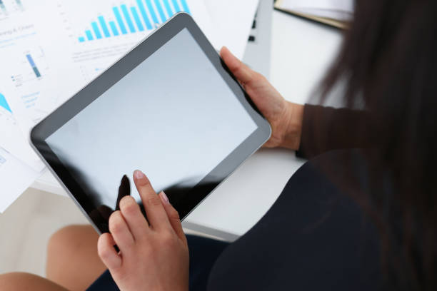 istock businesswoman study documents hold tablet in her hands closeup 1043420964