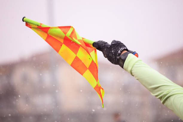 Soccer football referee assistant raises the flag. Blurred snowy background Soccer football referee assistant raises the flag. Blurred snowy background, close up view. offside stock pictures, royalty-free photos & images
