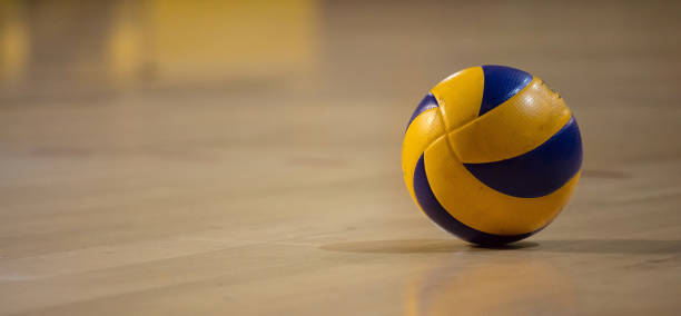 volleyball-ball auf unscharfen parkett hintergrund. banner, raum für text, nahaufnahme mit details. - volley stock-fotos und bilder