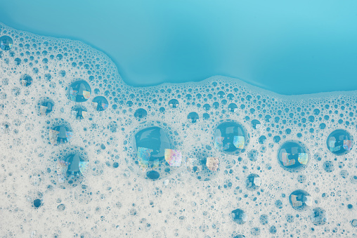 Espuma de la burbuja en la vista superior de la superficie del fondo de agua azul photo