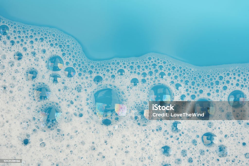 Bubble foam on blue water surface background top view Soap Sud Stock Photo