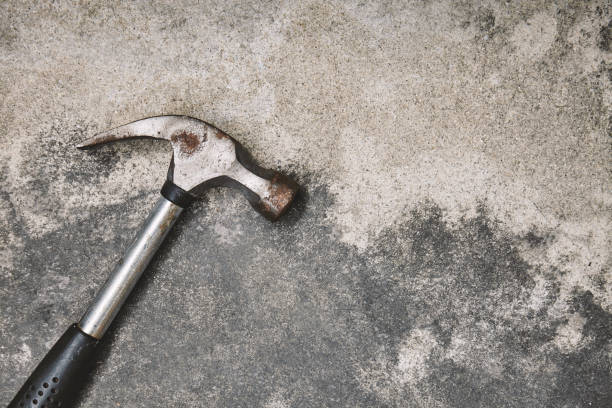istock Old steel oxide hammer on cement background 1043438300