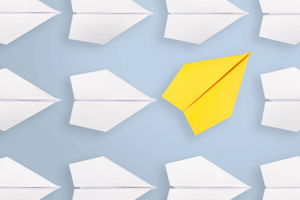 istock Change concepts with yellow paper airplane leading among white 1043450218