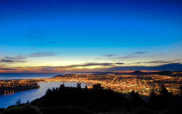 Scenic view of Dunedin City, South island, New Zealand Hill top view of Dunedin City. From the top, one can enjoy beautiful city lights, sunset and colorful sky. Dunedin is a popular tourist destination in South Island of New Zealand. dunedin new zealand stock pictures, royalty-free photos & images