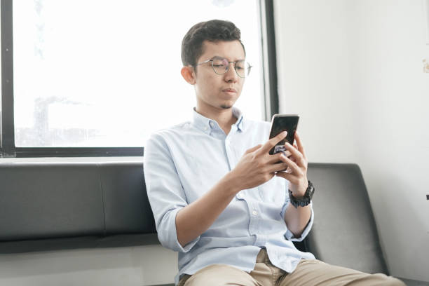 istock Southeast Asia Young Man Playing Smartphone 1043452914