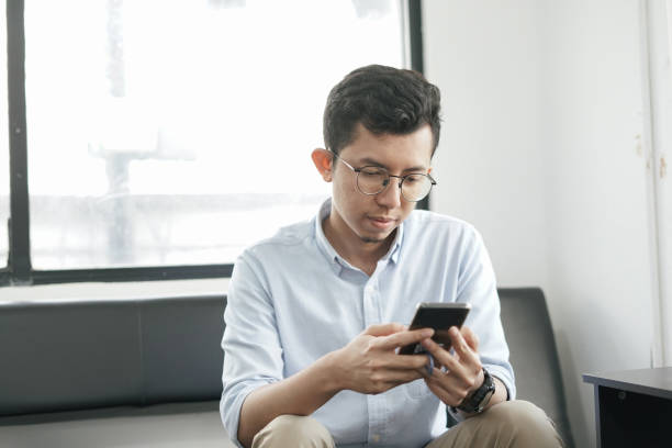 istock Southeast Asia Young Man Playing Smartphone 1043453008