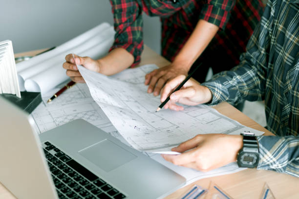 istock Architects working with blueprints and discussing project together at the meeting in the office. 1043458338