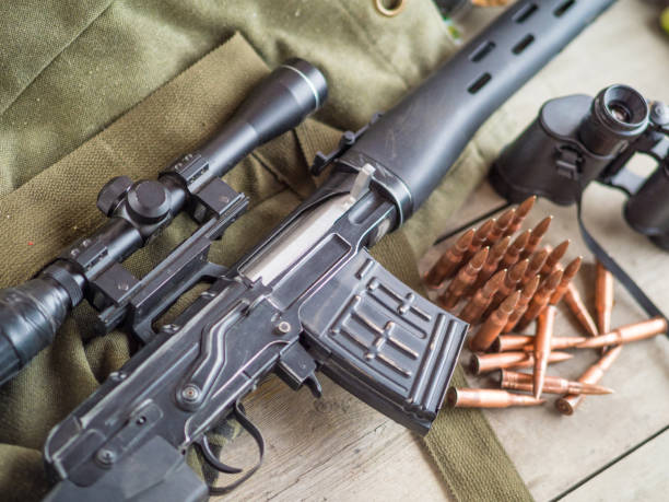 istock Sniper rifle, binoculars and ammunition on the wooden floor. 1043458996