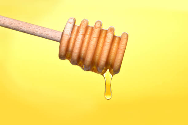 istock Honey is pouring from wooden dipper 1043461666