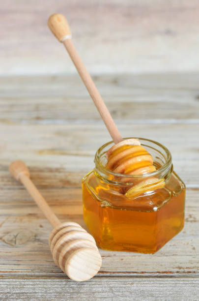 istock Honey is pouring on wooden dipper 1043461814