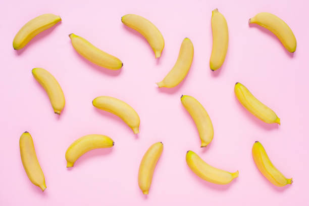 istock Pink background with small yellow bananas 1043464326