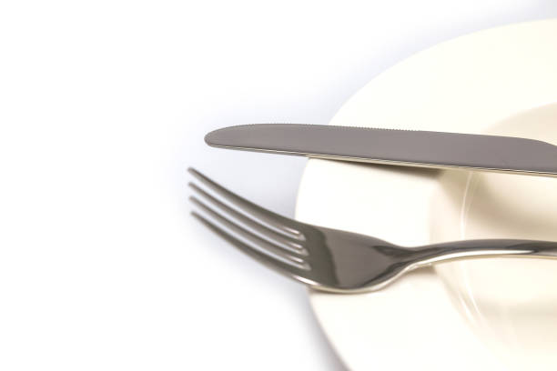 istock Stainless steel fork and knife on a white plate isolated 1043468080