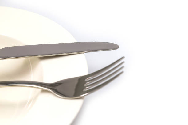 istock Stainless steel fork and knife on a white plate isolated 1043470958