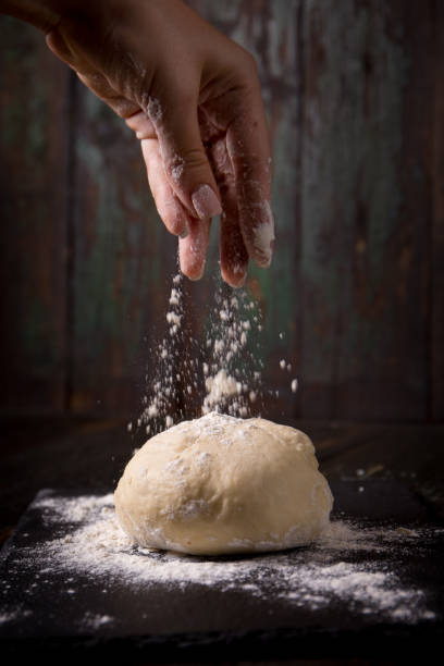 hand pours flour stock photo