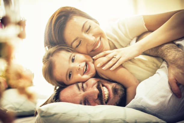 Our love is a real treasure. Our love is a real treasure. Happy family playing in bed. Space for copy. Close up. waking up photos stock pictures, royalty-free photos & images