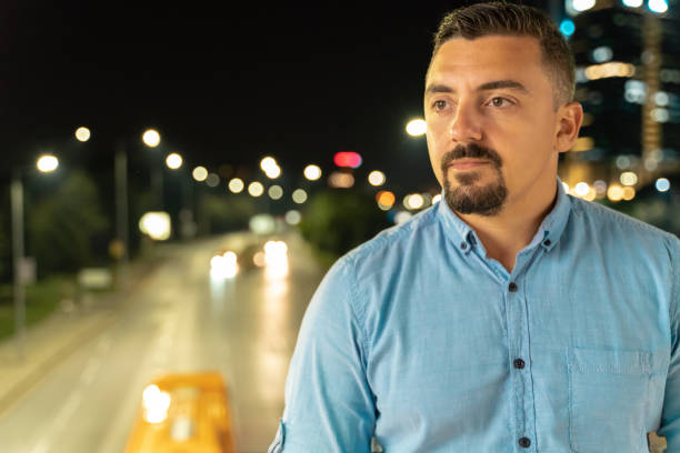 istock Handsome man standing outdoors at night contemplating 1043479612