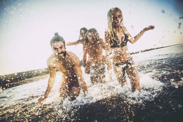 istock Carefree friends having fun while running through sea. 1043483092