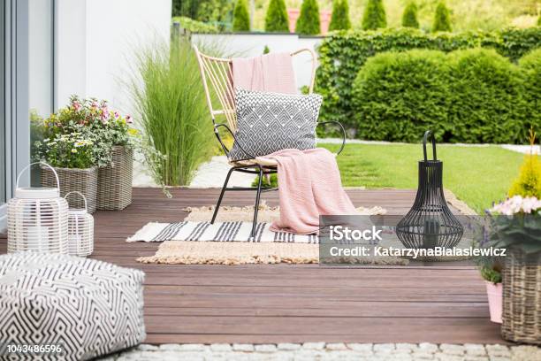 Real Photo Of A White Pillow And Pink Blanket On A Rattan Chair Standing In The Garden Of A Luxurious House Stock Photo - Download Image Now