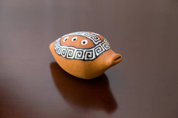 Closeup of a sazsyrnay - kazakh traditional ocarina isolated on dark wooden background