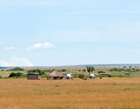 Olkiombo Bush airstrip, Masai Mara National Park, Kenya, Africa. Aircraft awaiting turn around on the remote bush airstrip of Olkiombo in the Masai Mara National Park. Light aircraft are the best way to access safari and wildlife reserve areas in the Mara.