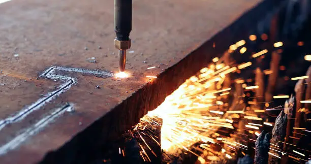 Oxygen torch cuts steel sheet. CNC gas cutting machine. Bright sparks of melting metal