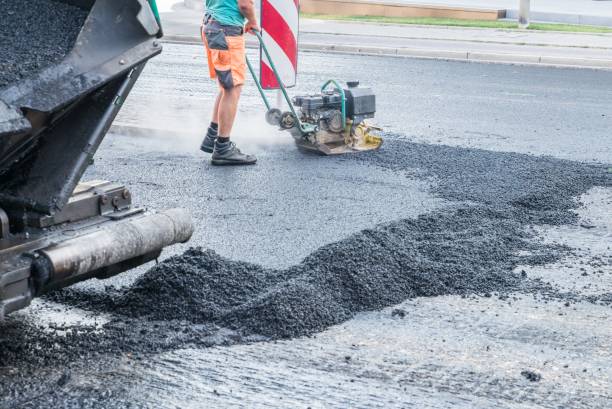 istock Road workers compact the asphalt with a vibrating rammer on the road, Germany 1043497304