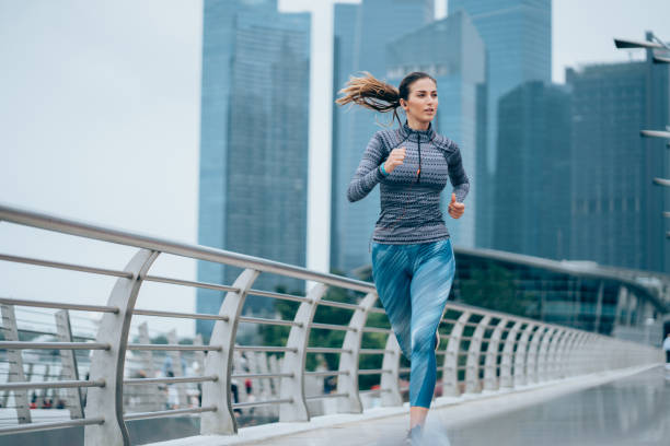 sportiva che corre sul ponte - singapore city foto e immagini stock