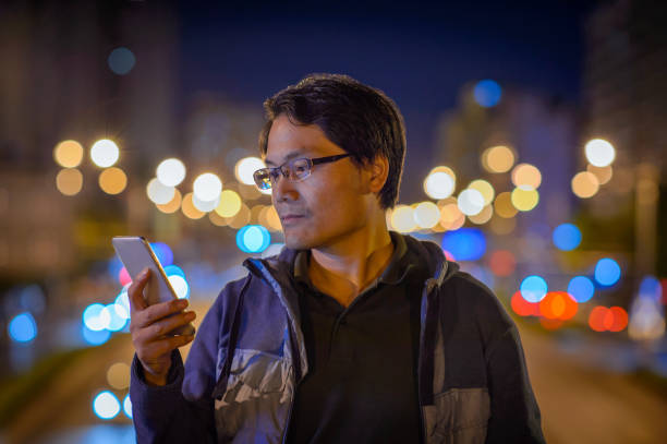 istock Man using digital tablet on night beauty light bokeh in city 1043515252
