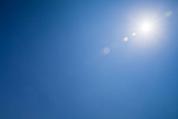 istock Lens flare optical effect over blue sky 1043519672