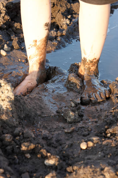 istock two children's feet walking in the mud 1043527616