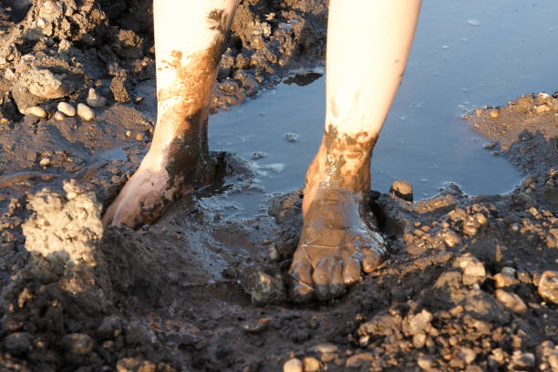 istock two children's feet walking in the mud 1043527660