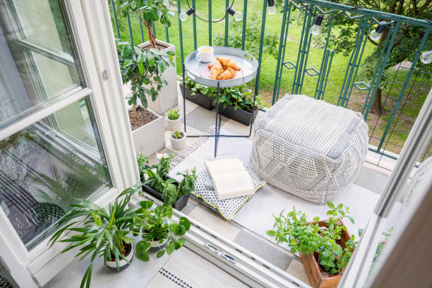 draufsicht auf einen balkon mit pflanzen, hocker eine tabelle mit frühstück - balkon fotos stock-fotos und bilder