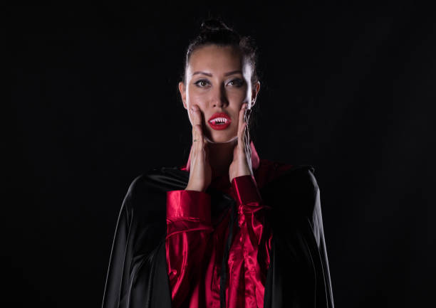 istock woman vampire, Dracula, studio portrait on a black background 1043532190