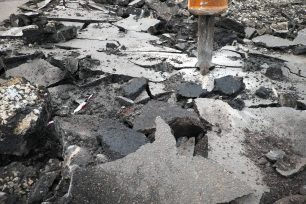 istock Excavator breaking concrete road surface with hydrohammer drill at repairing roadwork. Overhaul of the road, place of repair 1043545806