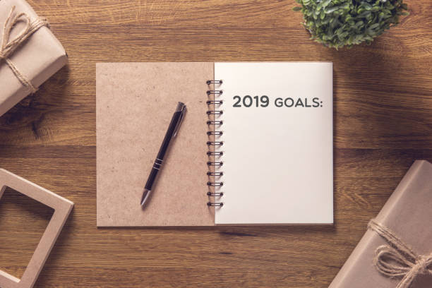 2019 goals list in notebook with gift box new year on wooden table background. 2019 goals list in notebook with gift box new year on wooden table background. 2019 new year resolution stock pictures, royalty-free photos & images