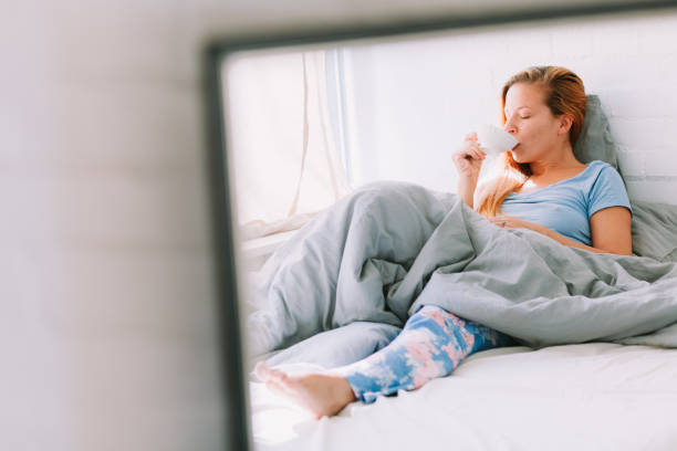 istock Young woman drinking coffee in bed 1043549832