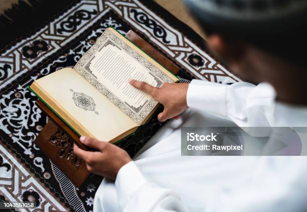 Muslim Man Studying The Quran - Fotografias de stock e mais imagens de Aprender - Aprender, Alcorão, Islamismo