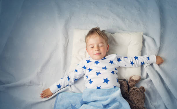 istock six years old child sleeping in bed with alarm clock 1043553568