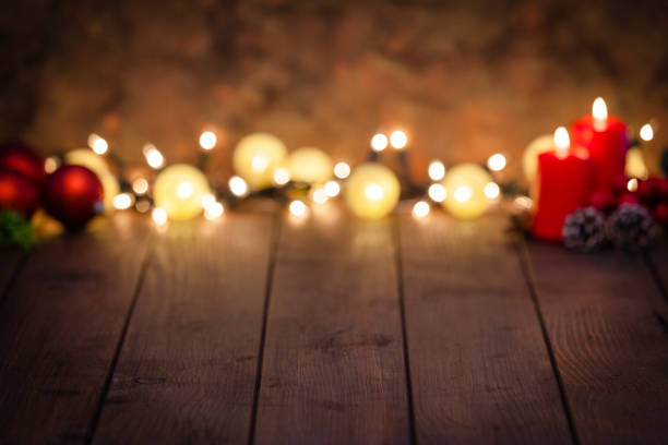 istock Empty rustic wooden table with Christmas lights at background 1043554452