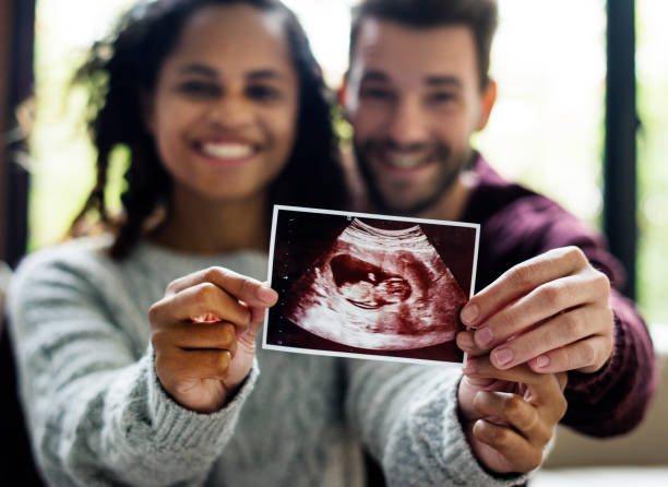 Happy couple with pregnancy news Happy couple with pregnancy news medical scan photos stock pictures, royalty-free photos & images