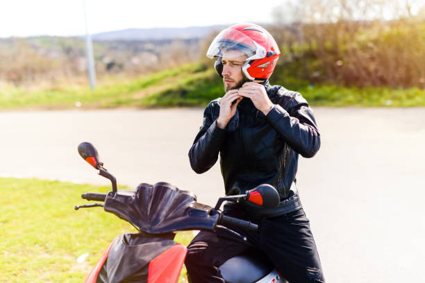 giovane bell'uomo seduto sulla sua bici con il casco tra le mani. - motorcycle biker sport city foto e immagini stock