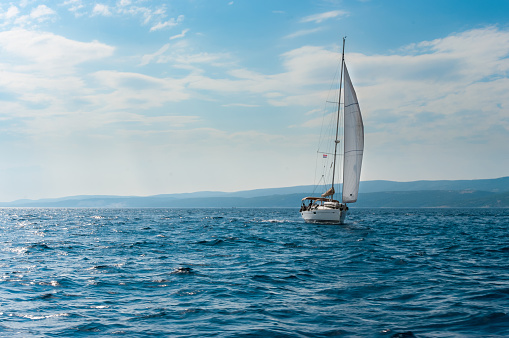 white sailboat sail on the Adriatic sea near Brac island on a windy summer morning. Blue skay and blue sea.