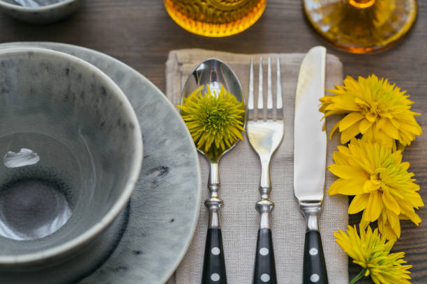 istock Rustic table setting with linen napkin, cutlery, ceramic plates, yellow glasses and yellow flowers 1043565098