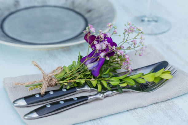 istock Rustic table setting with purple flowers on light wooden table. 1043565334