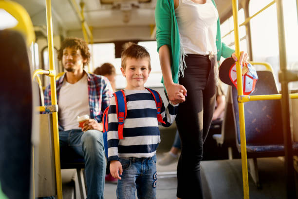 picture of cute little boy in a bus. looking at he camera and holding his mothers hand. - bus family travel destinations women imagens e fotografias de stock