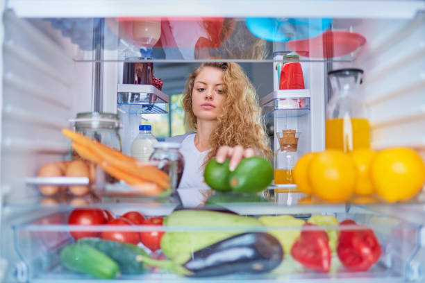 istock Woman taking avocado from fridge. 1043568758