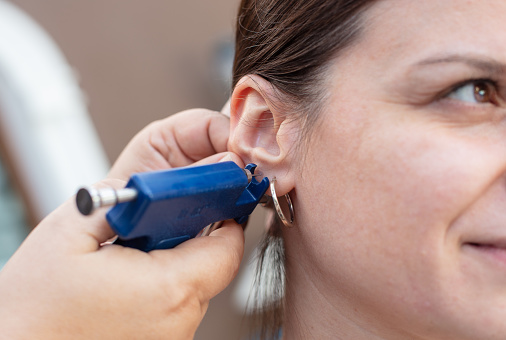 Mujer que tiene el proceso de perforación del oído photo