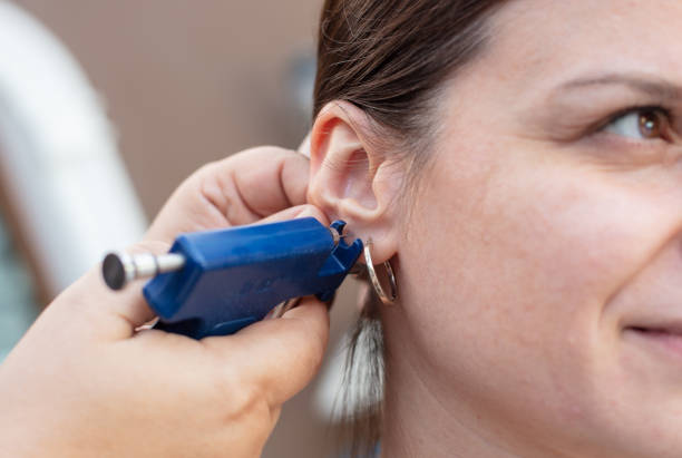 Woman having ear piercing process Woman having ear piercing process with special piercing gun in beauty center by medical worker, cropped close up view piercing stock pictures, royalty-free photos & images